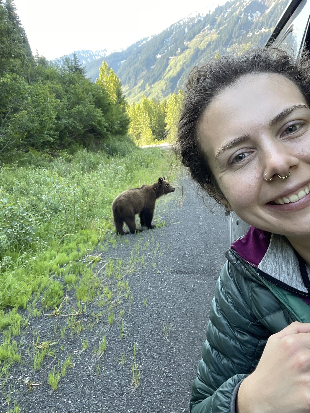 Karolina taking a photo near a wild brown bear in the mountains