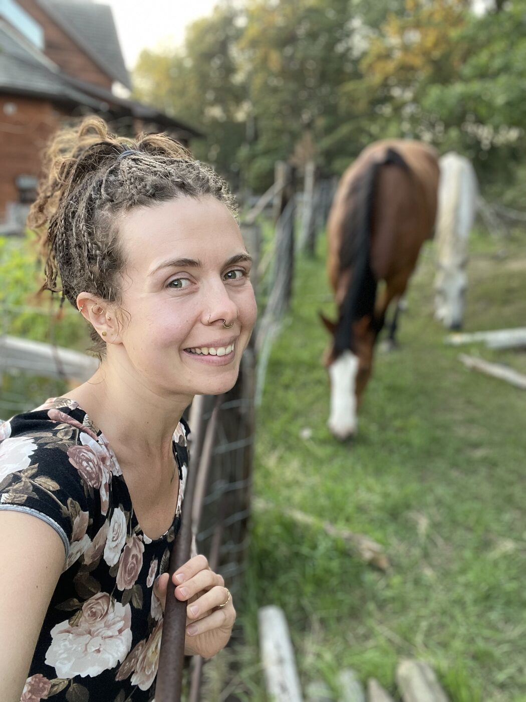 Karolina smiling beside a grazing horse